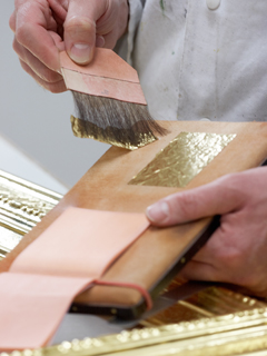 Blattgold wird mit Pinsel aufgenommen